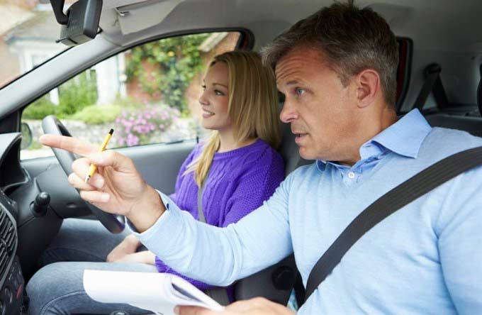 Insegnante di guida che insegna ad una ragazza al volante
